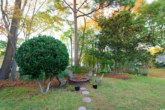 view of yard featuring a playground and a fire pit