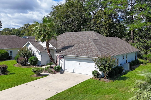 view of front of home with a garage, central AC unit, and a front lawn