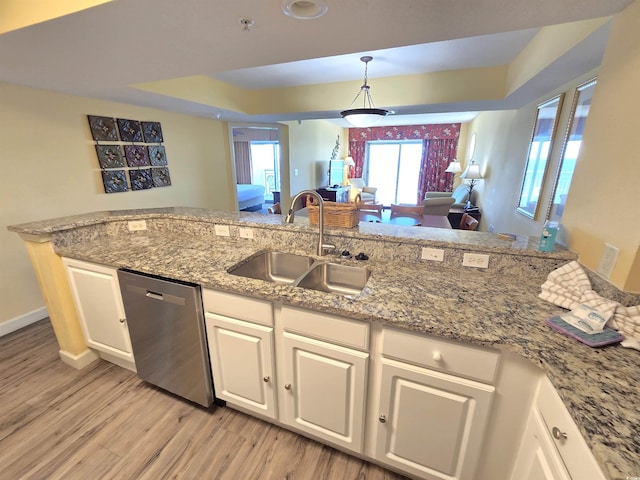 kitchen featuring sink, stainless steel dishwasher, white cabinets, and light stone countertops