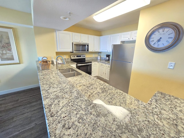 kitchen featuring sink, stainless steel appliances, kitchen peninsula, and white cabinets