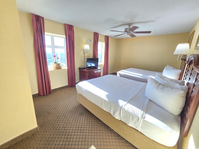 carpeted bedroom featuring ceiling fan and multiple windows