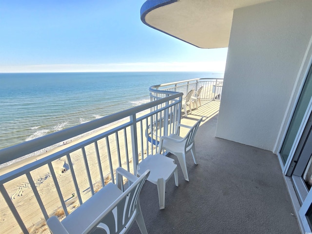 balcony with a water view and a beach view