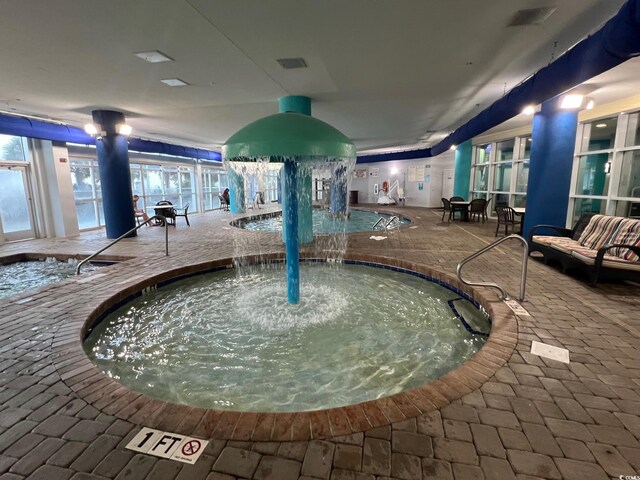 community pool featuring a patio area and a hot tub