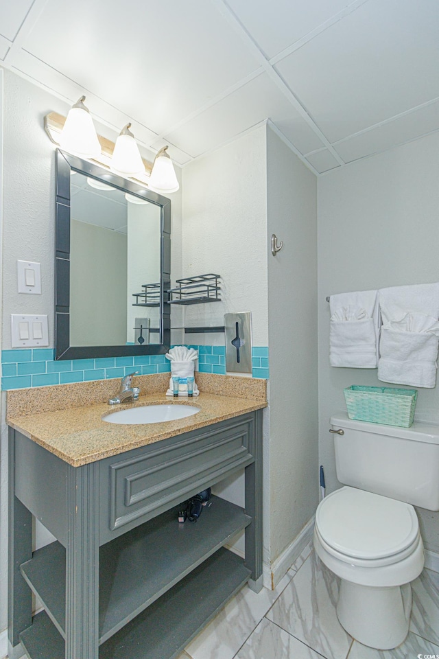 bathroom featuring vanity, decorative backsplash, and toilet