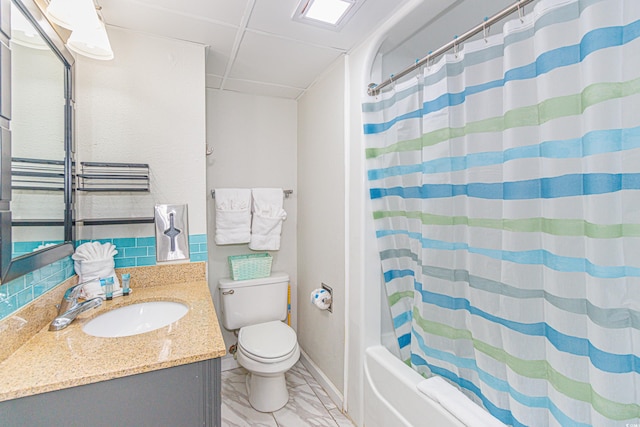 full bathroom featuring shower / bathtub combination with curtain, vanity, toilet, and a drop ceiling