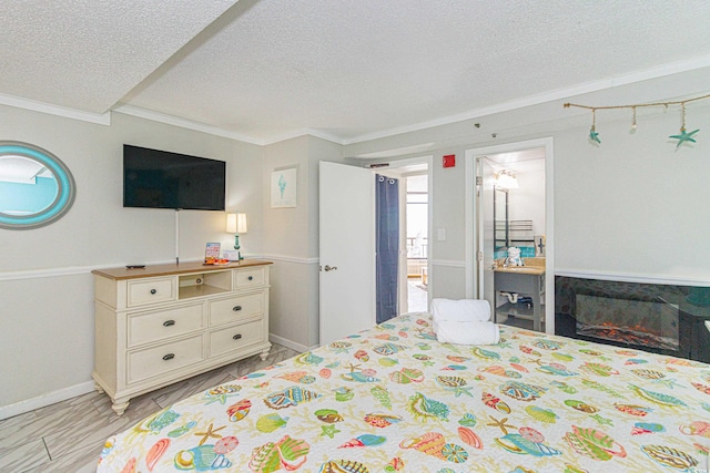 bedroom featuring crown molding, a textured ceiling, and ensuite bath