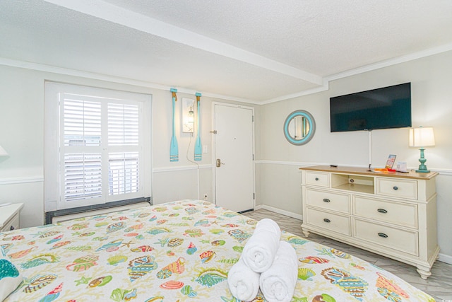 bedroom with crown molding, a textured ceiling, and baseboard heating