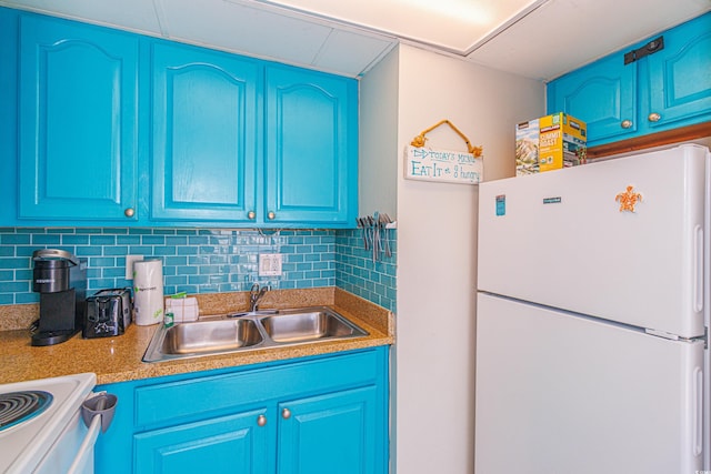 kitchen featuring tasteful backsplash, white appliances, blue cabinetry, and sink