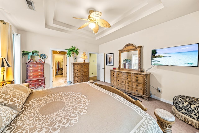 bedroom with carpet, ceiling fan, and a tray ceiling