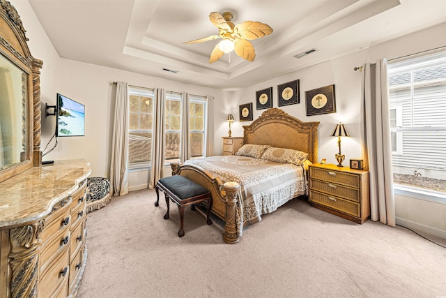 bedroom featuring carpet floors, ceiling fan, and a tray ceiling