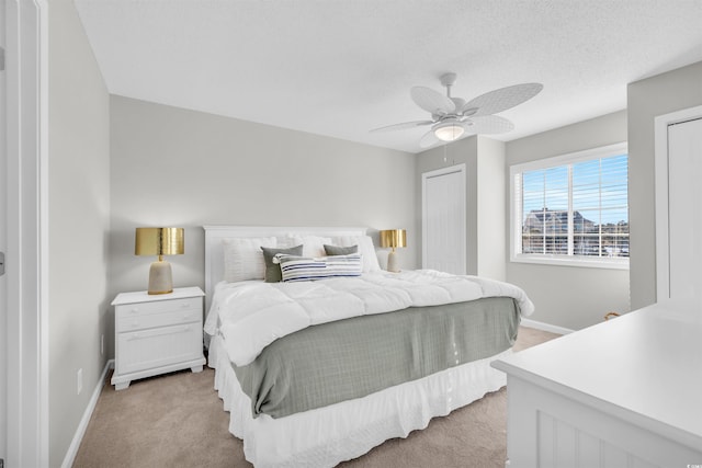 carpeted bedroom featuring a textured ceiling and ceiling fan