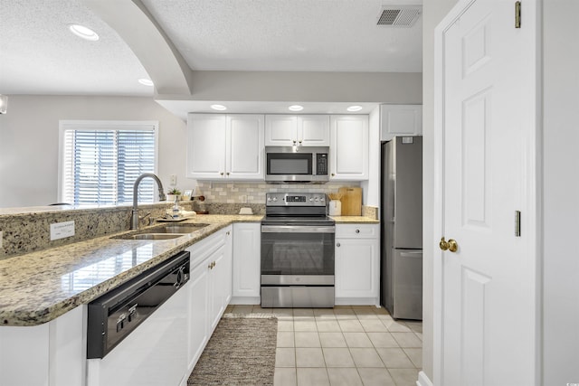 kitchen featuring sink, tasteful backsplash, kitchen peninsula, stainless steel appliances, and white cabinets