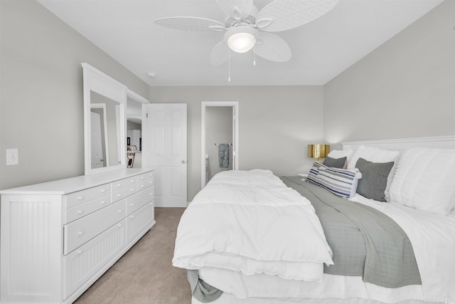 bedroom featuring ceiling fan, connected bathroom, and light carpet