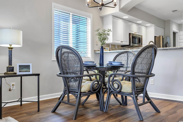 dining space featuring dark hardwood / wood-style flooring and a notable chandelier