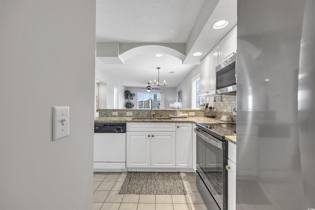 kitchen with appliances with stainless steel finishes, sink, white cabinets, and dark stone counters