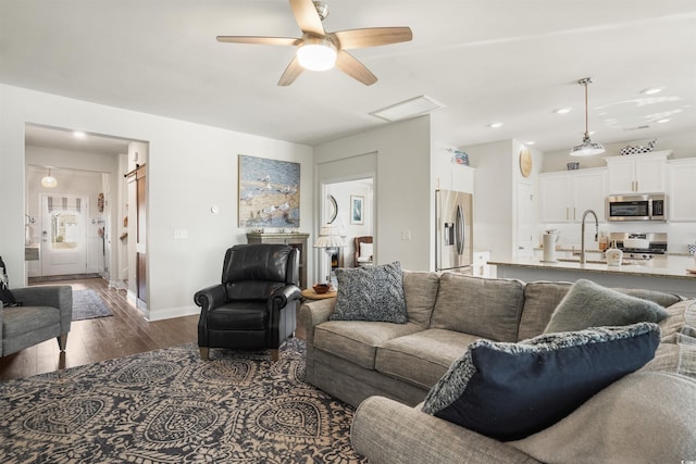 living room featuring ceiling fan, dark hardwood / wood-style floors, and sink