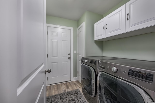 laundry area featuring cabinets, independent washer and dryer, and hardwood / wood-style floors