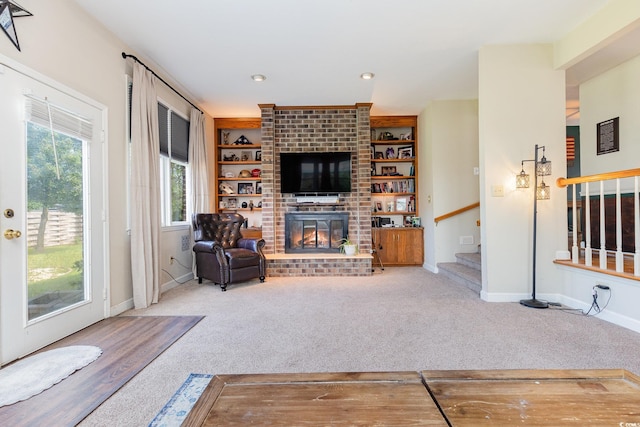 living room with a fireplace, built in features, and carpet flooring