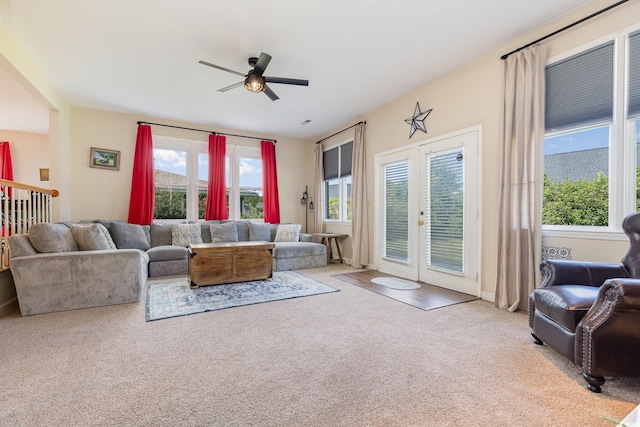 living room featuring light colored carpet, ceiling fan, and french doors