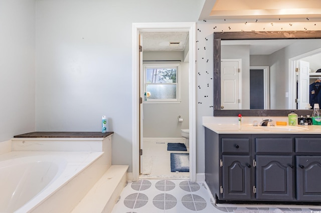 bathroom with vanity, a bath, a textured ceiling, tile patterned floors, and toilet