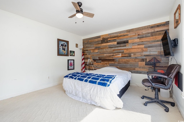 carpeted bedroom with ceiling fan and wooden walls