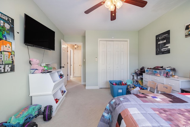 bedroom featuring light carpet, ceiling fan, and a closet