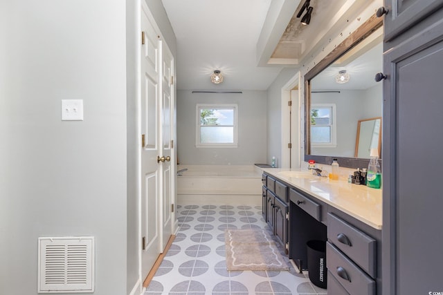 bathroom with vanity and a washtub