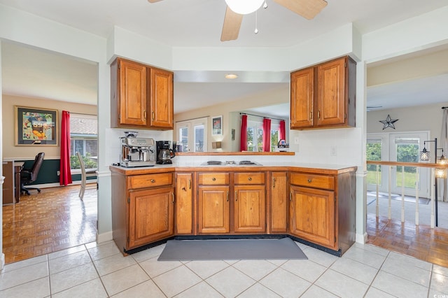 kitchen featuring decorative backsplash, white cooktop, kitchen peninsula, and light parquet flooring