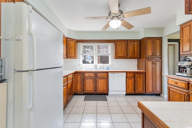 kitchen featuring tile countertops, tasteful backsplash, light tile patterned floors, ceiling fan, and white appliances