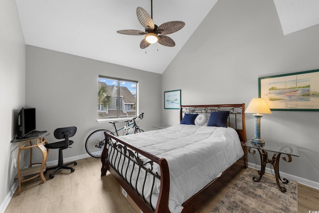 bedroom with ceiling fan, hardwood / wood-style floors, and high vaulted ceiling