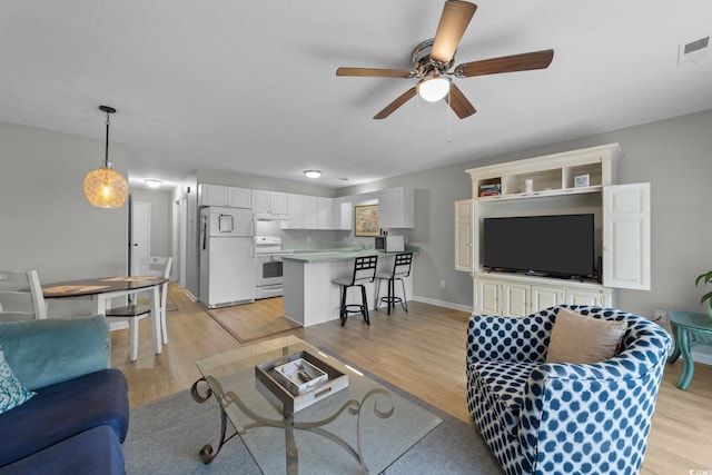 living room featuring light hardwood / wood-style floors and ceiling fan