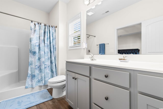 full bathroom with vanity, hardwood / wood-style floors, shower / tub combo, and toilet