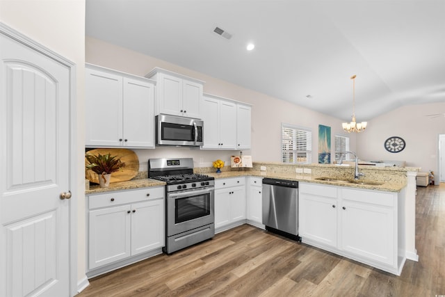 kitchen with white cabinetry, stainless steel appliances, kitchen peninsula, and sink