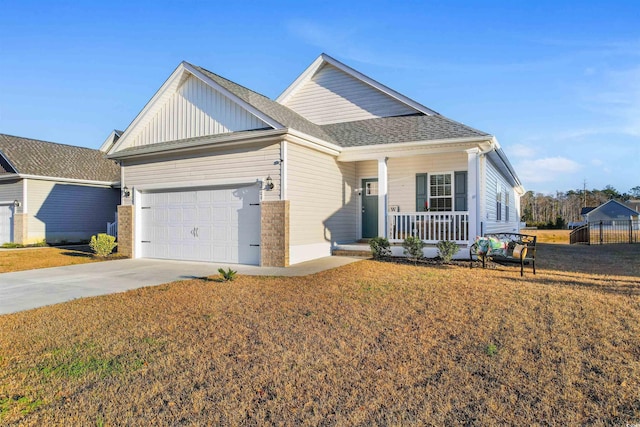 view of front of house with a garage, a front yard, and covered porch