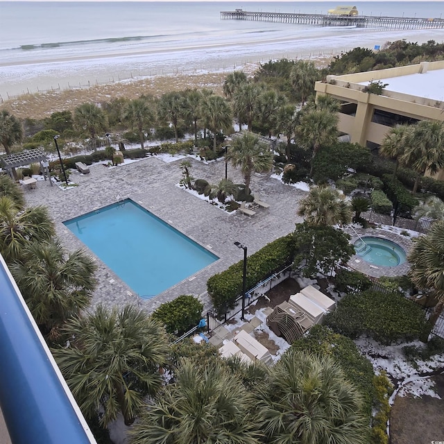 view of pool featuring a water view and a hot tub