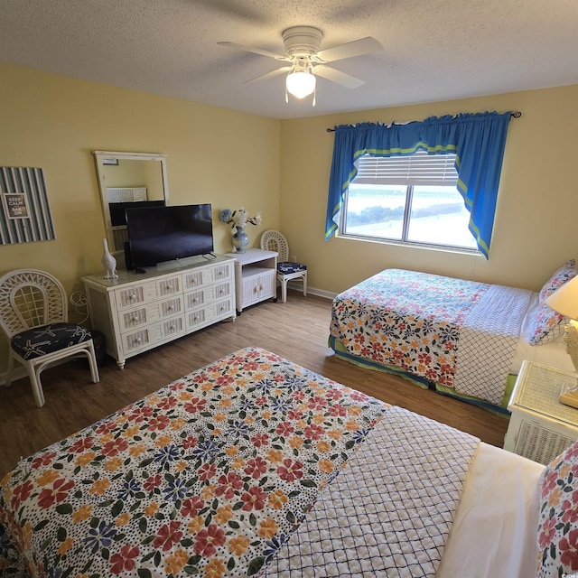 bedroom with hardwood / wood-style flooring, ceiling fan, and a textured ceiling