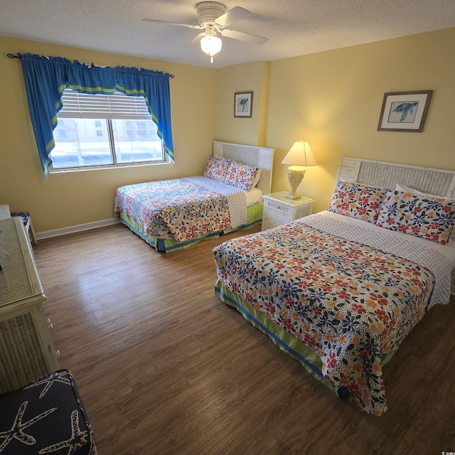 bedroom with ceiling fan, wood-type flooring, and a textured ceiling