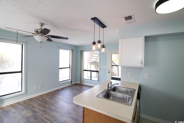 kitchen with sink, white cabinetry, a textured ceiling, dark hardwood / wood-style flooring, and decorative light fixtures