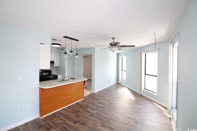 kitchen with pendant lighting, black electric range oven, sink, white cabinetry, and wood-type flooring