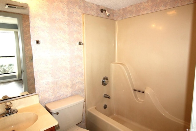 full bathroom with bathtub / shower combination, vanity, toilet, and a textured ceiling