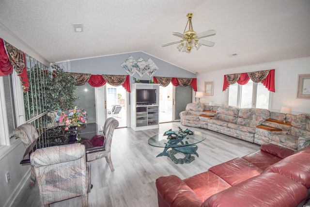 living room with ceiling fan, wood-type flooring, vaulted ceiling, and a wealth of natural light