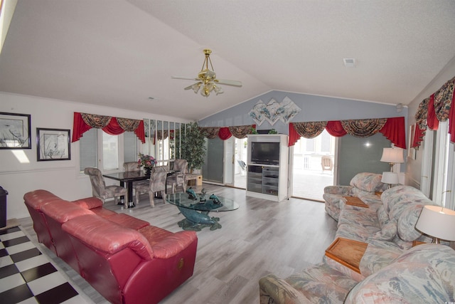 living room featuring vaulted ceiling, light hardwood / wood-style floors, and ceiling fan