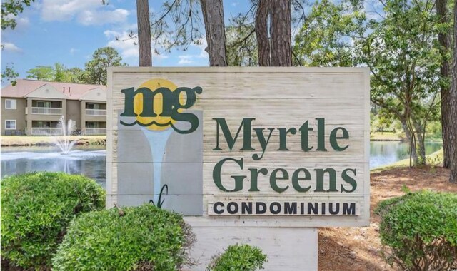 community / neighborhood sign featuring a water view