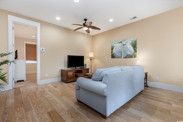 living room featuring ceiling fan and light hardwood / wood-style flooring