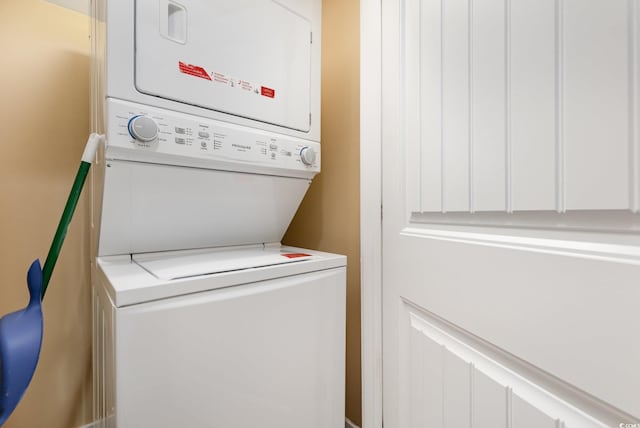 clothes washing area with stacked washer and clothes dryer