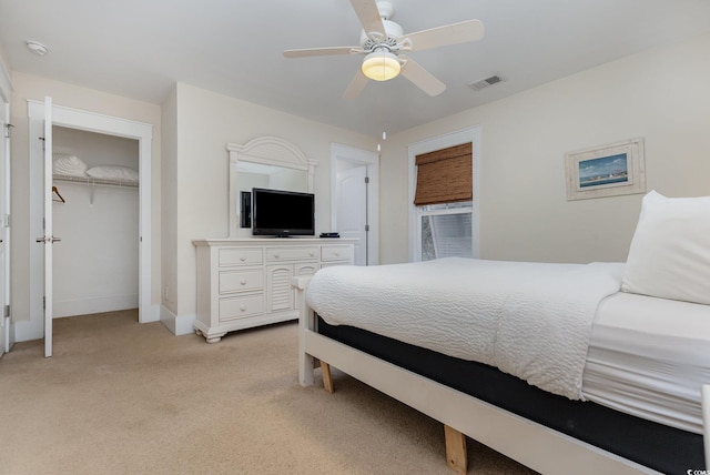 bedroom with light colored carpet, ceiling fan, and a closet