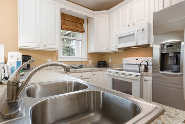 kitchen featuring sink, white appliances, light stone countertops, and white cabinets