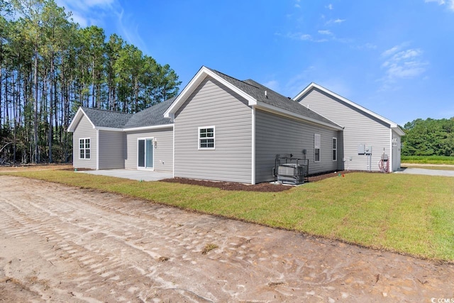 view of side of property featuring a patio area and a lawn