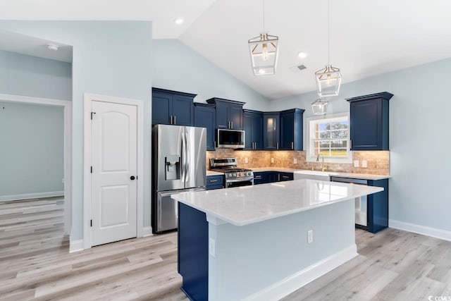 kitchen with a kitchen island, appliances with stainless steel finishes, pendant lighting, high vaulted ceiling, and blue cabinetry