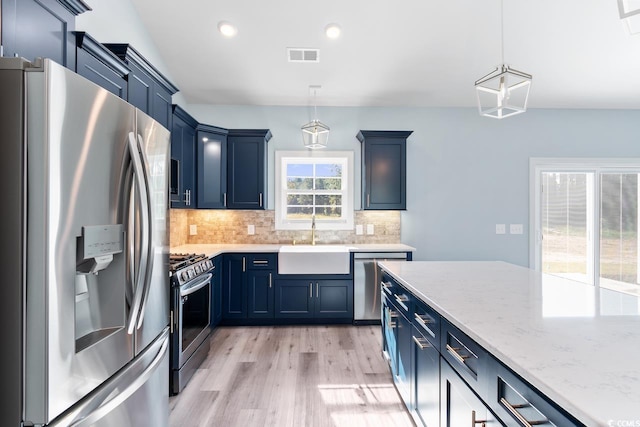 kitchen featuring blue cabinetry, appliances with stainless steel finishes, sink, and hanging light fixtures